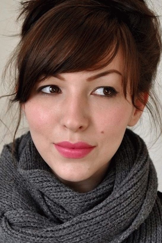 Mujer de cabello castaño con una explosión oblicua